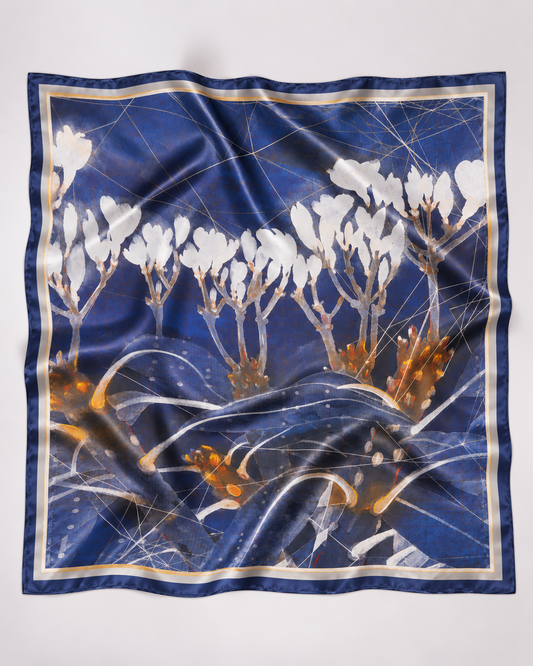 Blue silk scarf featuring white blossoms and gold botanical details